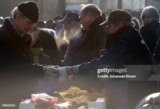 Poor people line up for food during a soup kitchen of charitable society Muenchner Tafel outside Capuchin Convent on December 21, 2007 in Munich,...
