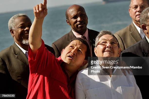President of Venezuela Hugo Chavez points something out to acting President of Cuba Raul Castro during the formal group photo session during the 4th...