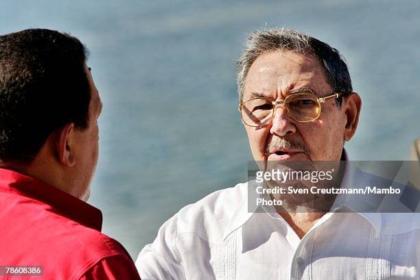 President of Venezuela Hugo Chavez talks with acting President of Cuba Raul Castro during the formal group photo session during the 4th PetroCaribe...