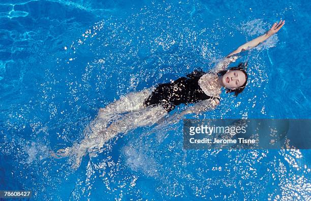 woman doing back stroke in swimming pool - backstroke stock pictures, royalty-free photos & images