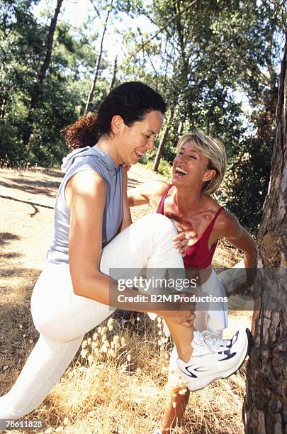 smiling mother and daughter in sportswear outdoors - family sports centre laughing stock-fotos und bilder