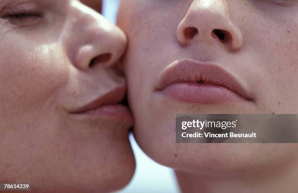 close-up of mother and daughter - extreme close up kiss stock pictures, royalty-free photos & images