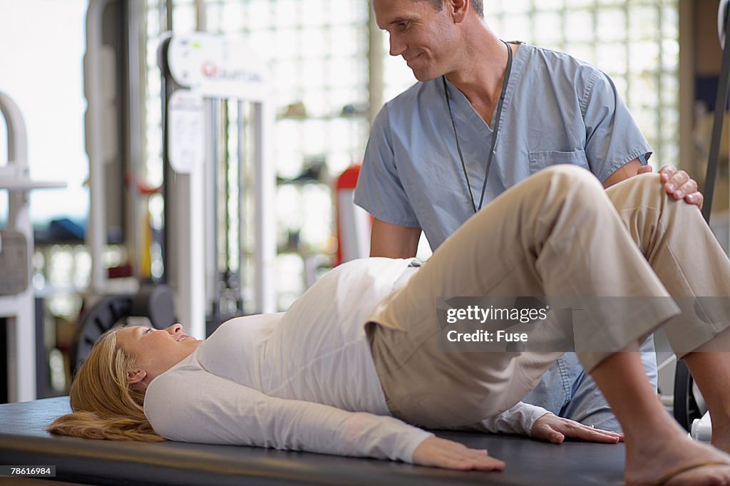 Nurse Assisting Pregnant Woman with Physical Therapy