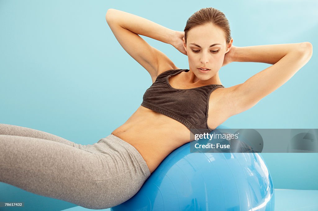 Young Woman Doing Sit-Ups on Exercise Ball