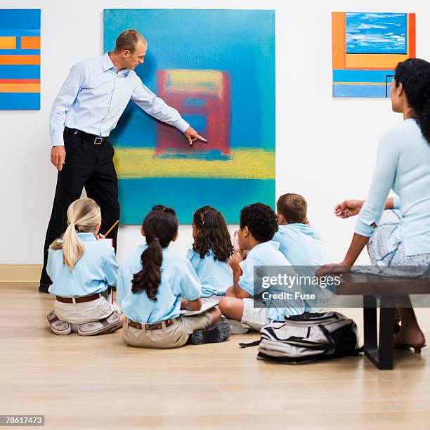 teacher and elementary students in art gallery - museum guide stock pictures, royalty-free photos & images