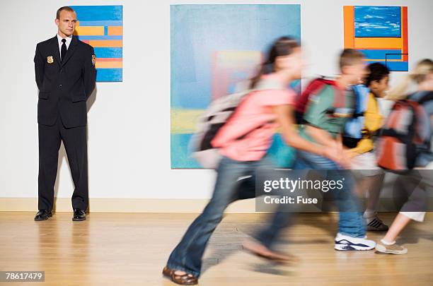security guard watching elementary students running - bokeh museum stock pictures, royalty-free photos & images