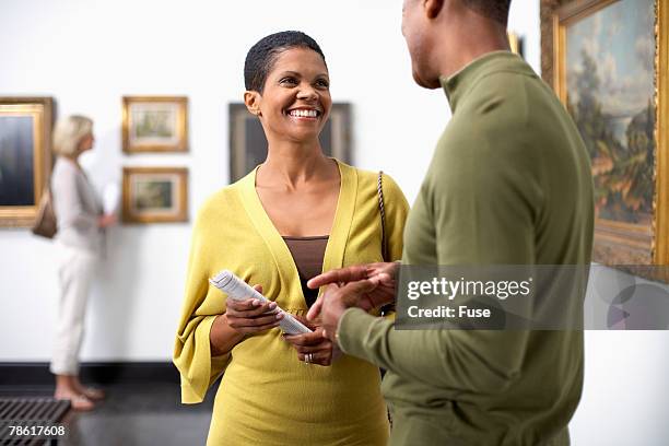 couple socializing at art gallery - art show stock pictures, royalty-free photos & images