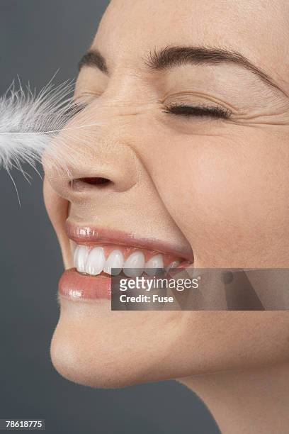 feather tickling woman's nose - tickling 個照片及圖片檔