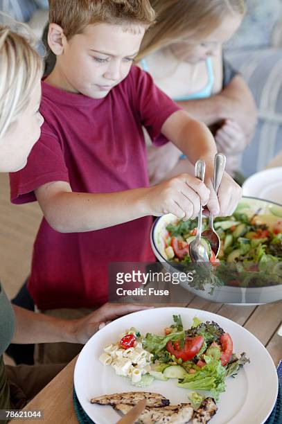 boy serving salad - wellness kindness love stock pictures, royalty-free photos & images