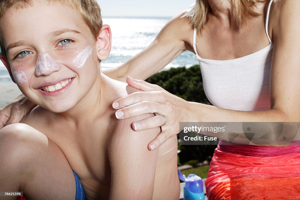 Mother Applying Sunscreen to Son