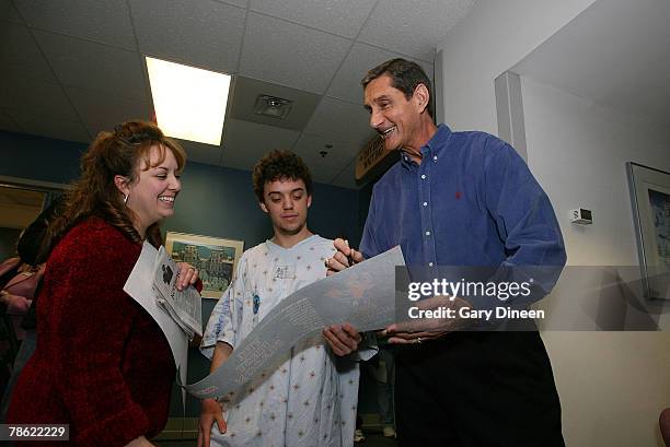 Milwaukee Bucks legend and founder of the MACC Fund Jon McGlocklin signs an autograph during a visit with patients and their families at the MACC...