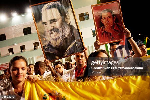Students from Venezuela hold pictures of President of Venezuela Hugo Chavez and President of Cuba Fidel Castro during the closing session of the 4th...