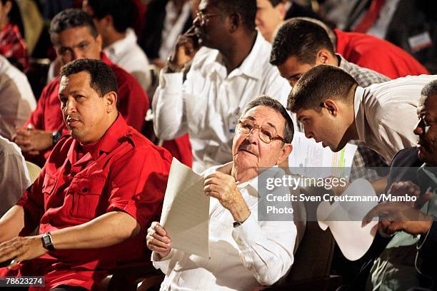 Acting President of Cuba Raul Castro talks to his grandson and bodyguard Raul Dominguez Castro as he sits next to President of Venezuela Hugo Chavez...