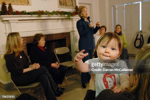 Eight month old Kathryn Applegate Smith plays in her mothers arms while U.S. Senator and presidential hopeful Hillary Clinton speaks during a...