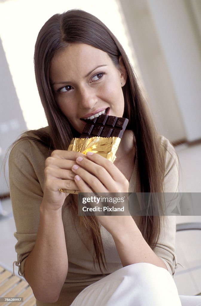 Woman biting into dark chocolate