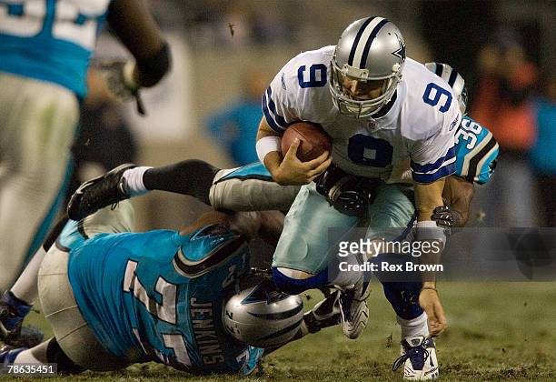 Marquand Manuel of the Carolina Panthers and teammate Kris Jenkins bring down Tony Romo of the Dallas Cowboys during the second half at Bank of...
