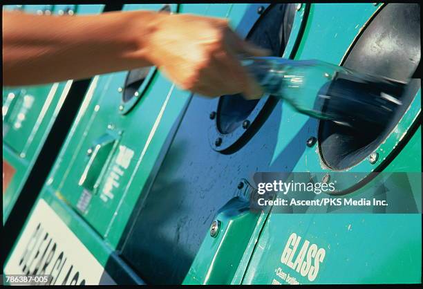 hand putting bottle into recycling bin, close-up - bottle bank stock pictures, royalty-free photos & images