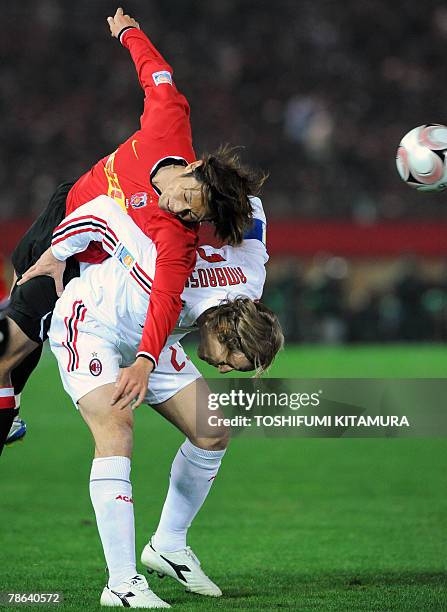 Asian champion Urawa Reds forward Yuichi Nagai heads the ball on against European champion AC Milan midfielder Massimo Ambrosini during their Club...