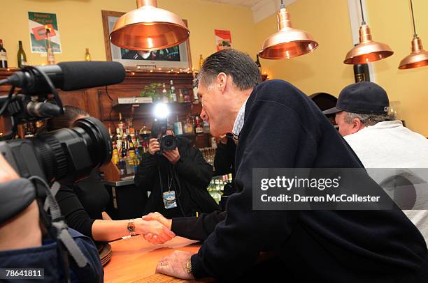 Republican presidential candidate and former Massachusetts Gov. Mitt Romney leans across the counter and shakes hands with diners at Nonni's Italian...