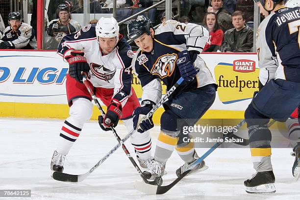 Jody Shelley of the Columbus Blue Jackets and Jordin Tootoo of the Nashville Predators get tangled up while battling for the puck on December 23,...