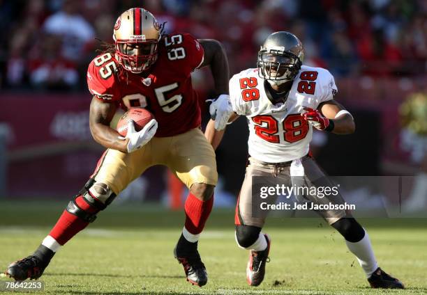 Vernon Davis of the San Francisco 49ers runs after a catch as Tanard Jackson of the Tampa Bay Buccaneers defends during an NFL game at Monster Park...