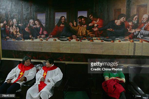 Members of the choir prepare for Christmas celebrations in front of a replica of Leonardo da Vinci's "Last Supper", in the Dongxin Christian Church...