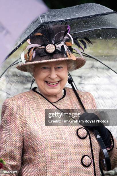 Queen Elizabeth II sheltering under an umbrella joins other members of the Royal Family for Christmas Day service at Sandringham Church on December...