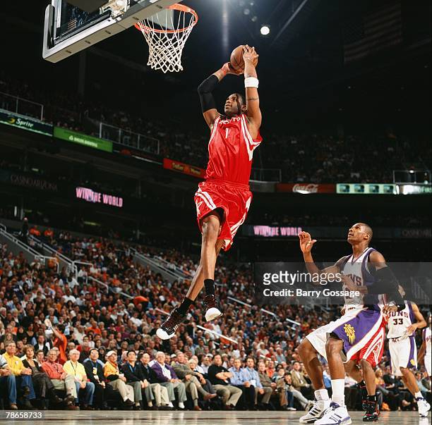 Tracy McGrady of the Houston Rockets takes the ball to the basket for a dunk past Leandro Barbosa of the Phoenix Suns during the game at U.S. Airways...