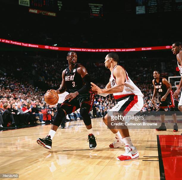 Dwyane Wade of the Miami Heat moves the ball against Brandon Roy of the Portland Trail Blazers during the game at the Rose Garden Arena on December...