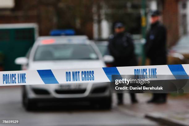 Police tape is pictured as police officers stand guard outside of a house in Edgeware on December 27, 2007 in London, England. A man is facing...