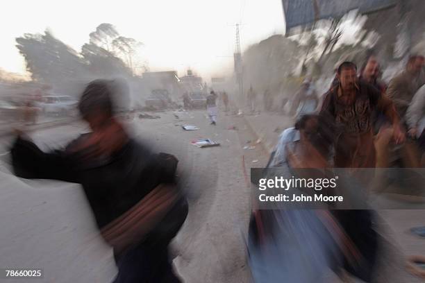 Survivors flee a bomb attack on former Prime Minister Benazir Bhutto December 27, 2007 in Rawalpindi, Pakistan. The opposition leader has died from...