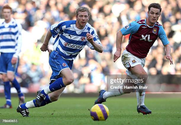 Brynjar Gunnarsson of Reading chases down the ball with Scott Parker of West Ham during the Barclays Premier League match between West Ham United and...