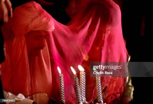 The bride, Benazir Bhutto and the groom, Asif Zardari, look to each other in a mirror in front of them at their wedding on December 18 at the Clifton...