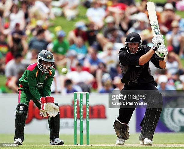 Peter Fulton of New Zealand plays a shot watched by Mushfiqur Rahim of Bangladesh during the second one day international match between New Zealand...