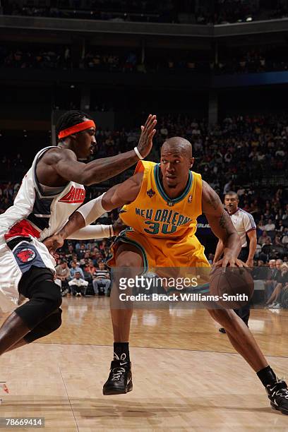 David West of the New Orleans Hornets tries to push past Gerald Wallace of the Charlotte Bobcats at the Charlotte Bobcats Arena December 28, 2007 in...