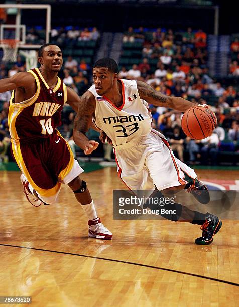 Jack McClinton of the Miami Hurricanes gets past Chris Gaynor of the Winthrop Eagles in the Orange Bowl Basketball Classic at Bank Atlantic Center...
