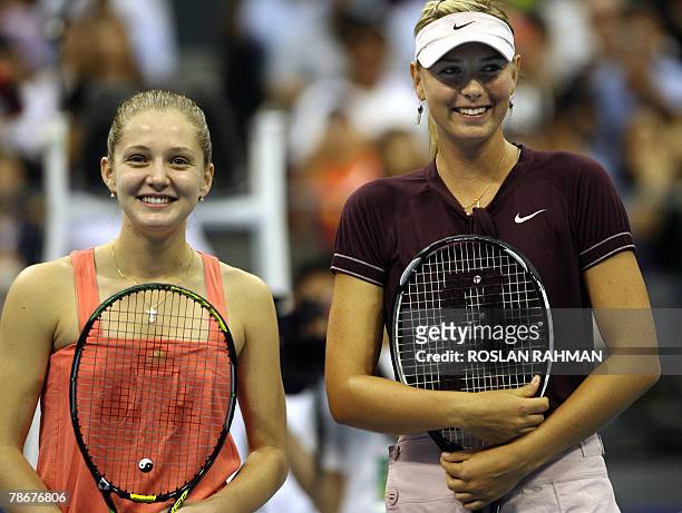 Russian tennis players Maria Sharapova and Anna Chakvetadze pose on the court before the start of the exhibition match in Singapore 30 December 2007....