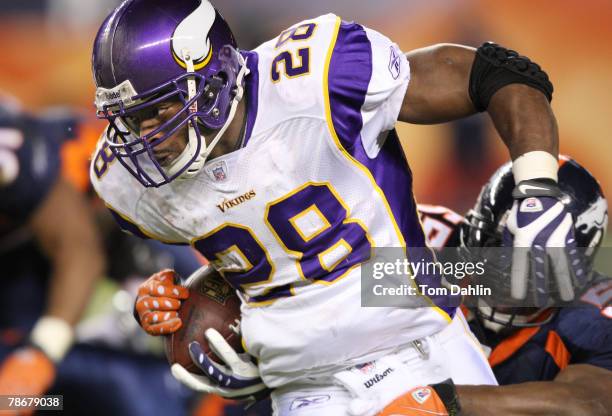 Running back Adrian Peterson of the Minnesota Vikings carries the ball at an NFL game against the Denver Broncos at Invesco Field at Mile High...