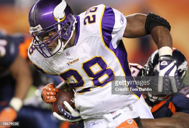 Running back Adrian Peterson of the Minnesota Vikings carries the ball at an NFL game against the Denver Broncos at Invesco Field at Mile High...