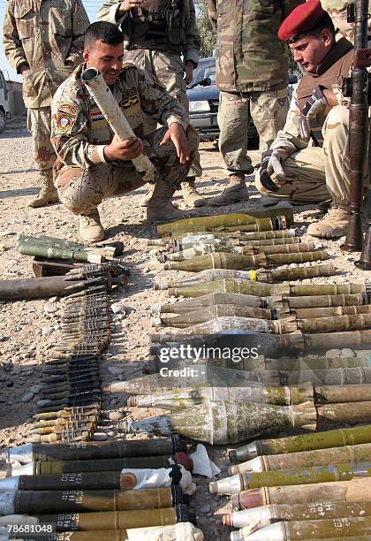 Iraqi soldiers lay on the ground the weapons they found in a cache in al-Haded, 10 kms from the restive city of Baquba, northeast of Baghdad, 31...