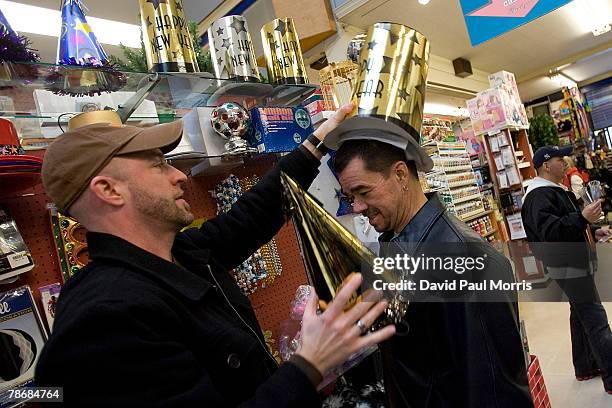 John Mendez tries on a hat as Micheal La Flash as they shop for New Years Eve party favors at Cliff's Variety Store December 31, 2007 in San...