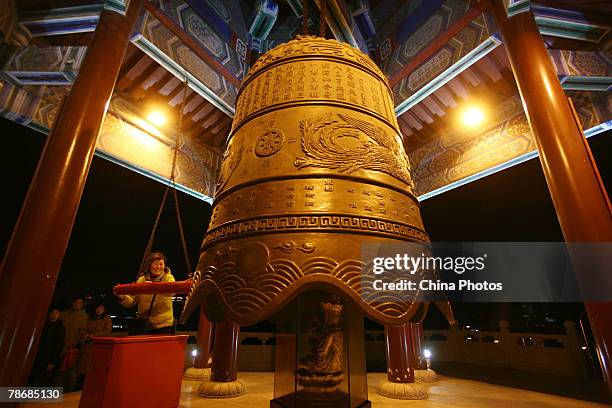 Woman tolls a bell to mark the 2008 New Year at the Xuanzang Temple December 31, 2007 in Nanjing of Jiangsu Province, China. Many 2008 Beijing...