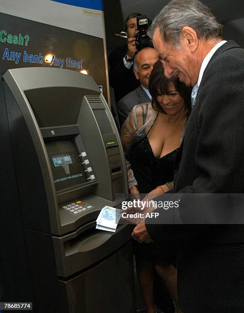 Cypriot President Tassos Papadopoulos takes the first euro banknotes from an ATM machine at the finance ministry in Nicosia, early 01 January 2008....