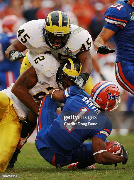 Wide receiver Percy Harvin of the Florida Gators is brought down by linebackers Shawn Crable and Obi Ezeh of the Michigan Wolverines in the Capital...