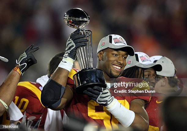 Defensive end Lawrence Jackson of the USC Trojans holds up the 94th Rose Bowl game winner's trophy after the USC Trojans defeated the Illinois...