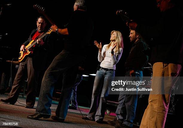 Republican Presidential hopeful and former Arkansas Governor Mike Huckabee plays bass guitar as actor Chuck Norris and his wife Gena dance during a...