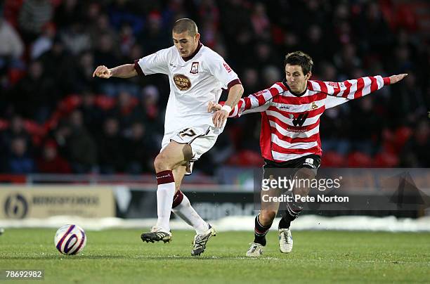 Brad Johnson of Northampton Town plays the ball under pressure from Brian Stock of Doncaster Rovers during the Coca Cola League One Match between...