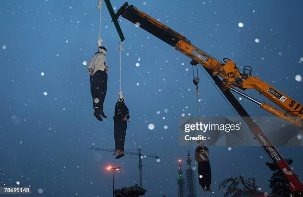 Three Iranian drug traffickers hang limply from the nooses as it snows in a square in central city of Qom, 120 kms south of capital Tehran, 02...