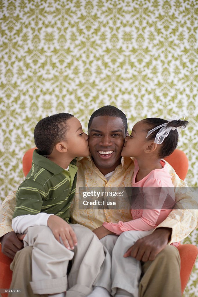 Children Kissing Their Father on His Cheeks