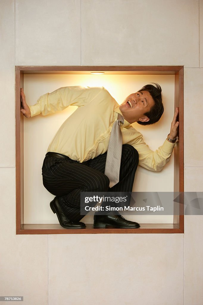 Young Businessman Trapped in a Square Recess